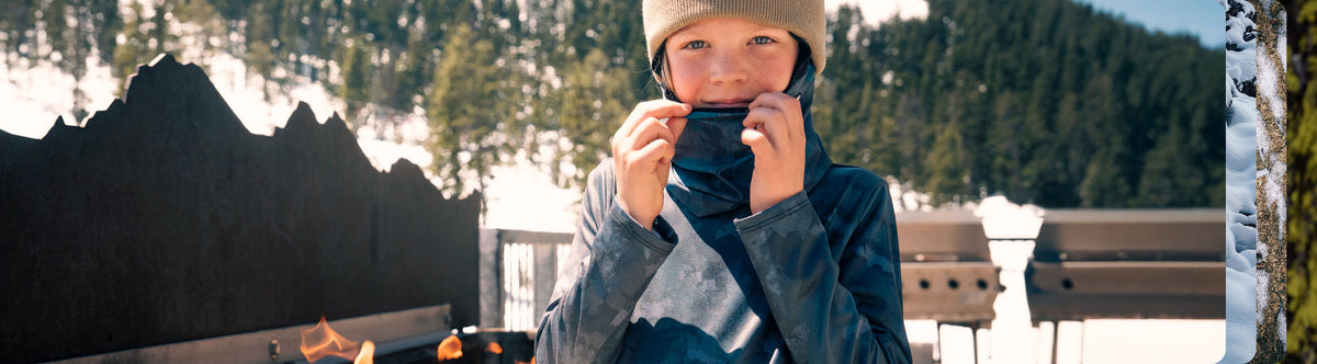 Kid sitting by the fire wearing Blackstrap Base Layer Crewneck