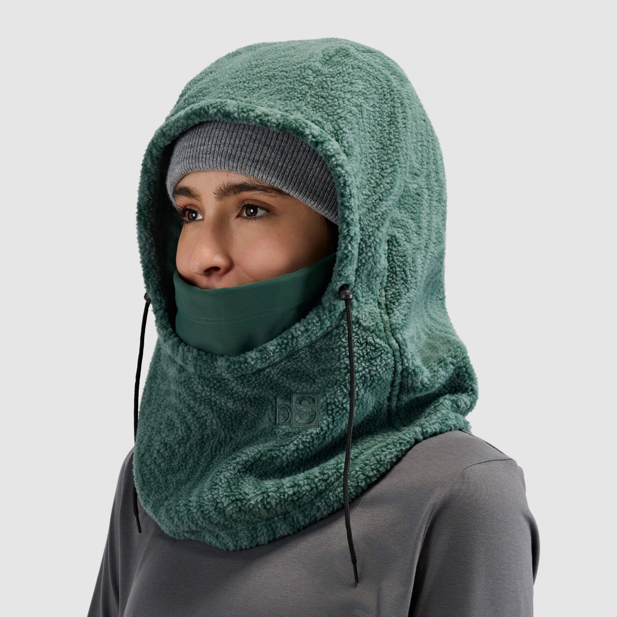 BlackStrap Caldera Hood Sherpa Fleece Overhood Inprint Obsidian worn by a woman wearing a beanie #color_inprint-obsidian