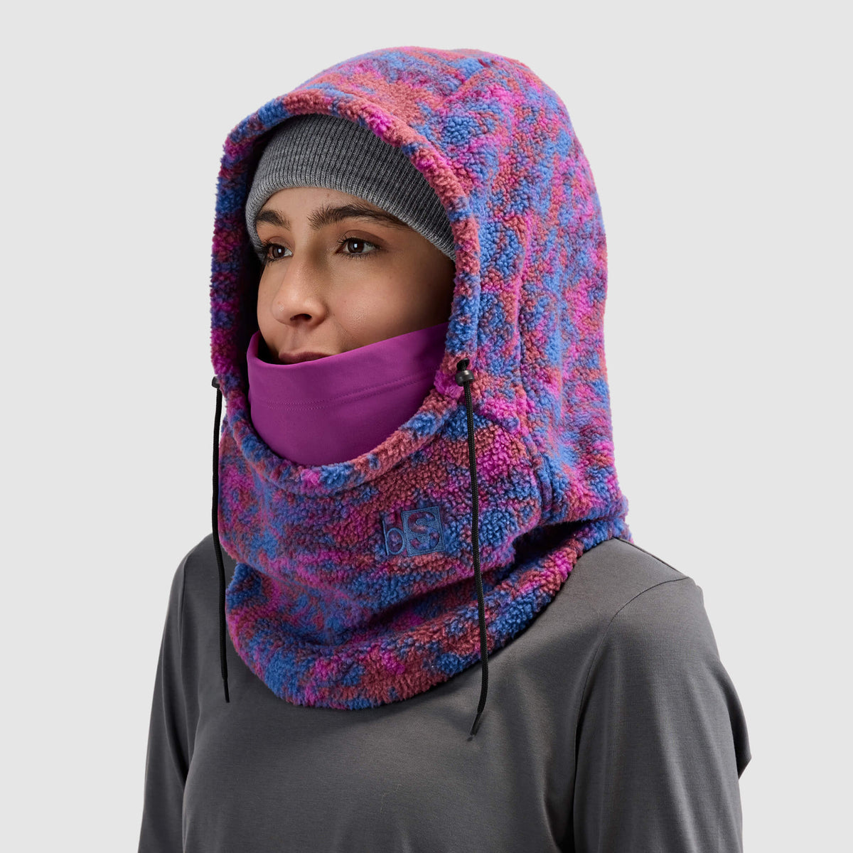 BlackStrap Caldera Hood Sherpa Fleece Overhood Pulse Currant worn by a woman wearing a beanie #color_pulse-currant