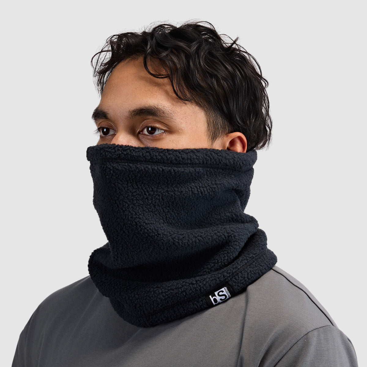 BlackStrap Caldera Sherpa Fleece Tube Neck Gaiter Black worn by a man up over the nose #color_black