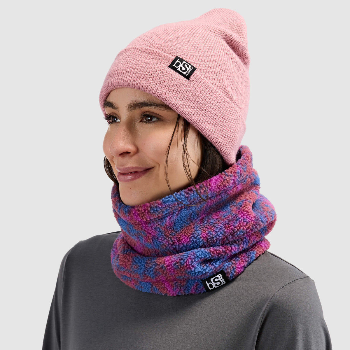 BlackStrap Caldera Sherpa Fleece Tube Neck Gaiter Pulse Currant worn by a woman with a beanie #color_pulse-currant