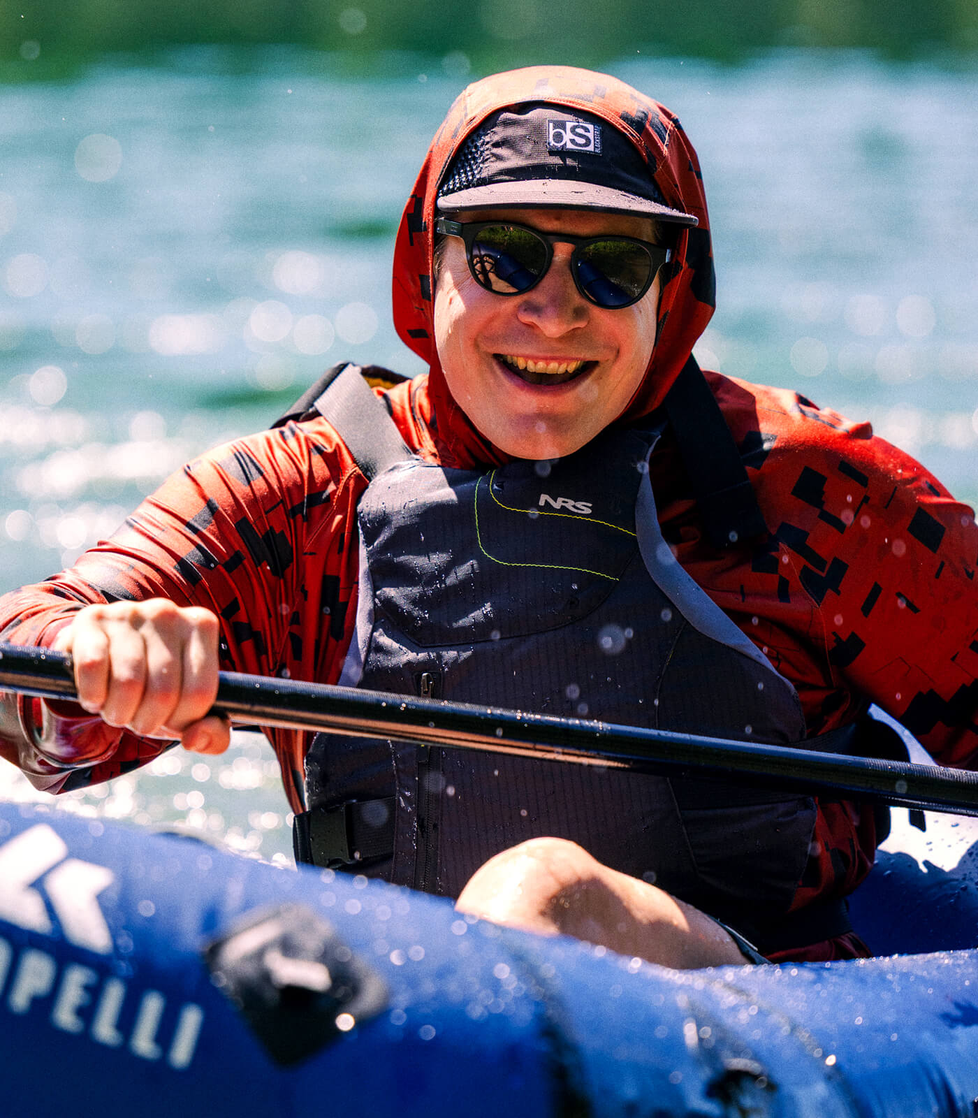Man white water rafting staying protected from the sun with his Brackish Sun Hoodie.