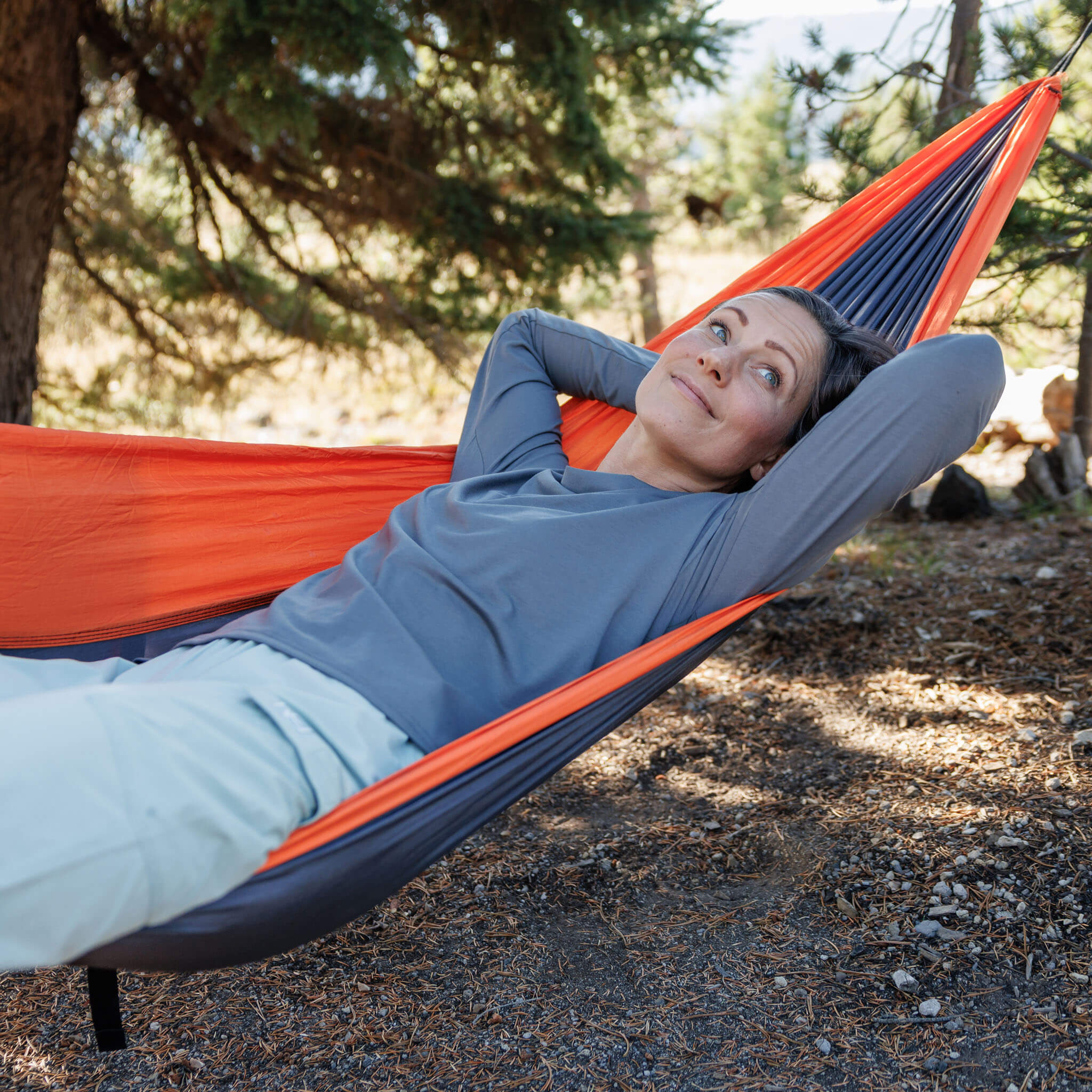 Woman relaxing in a hammock in a pine forest wearing the BlackStrap Women's Aspect Long Sleeve