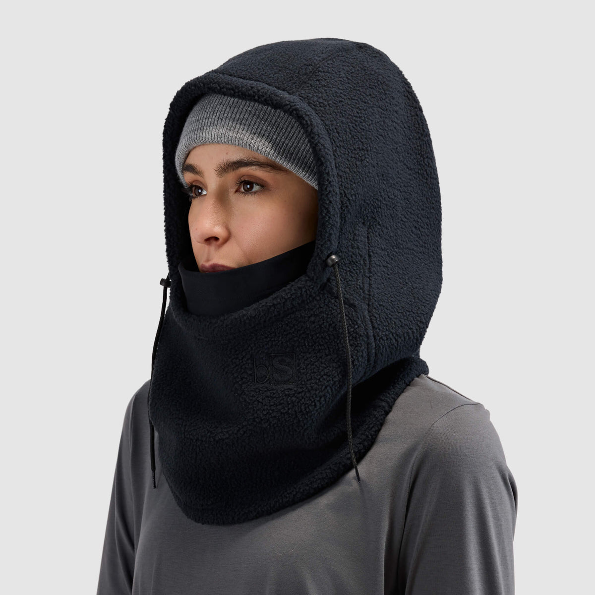 BlackStrap Caldera Hood Sherpa Fleece Overhood Black worn by a woman wearing a beanie #color_black
