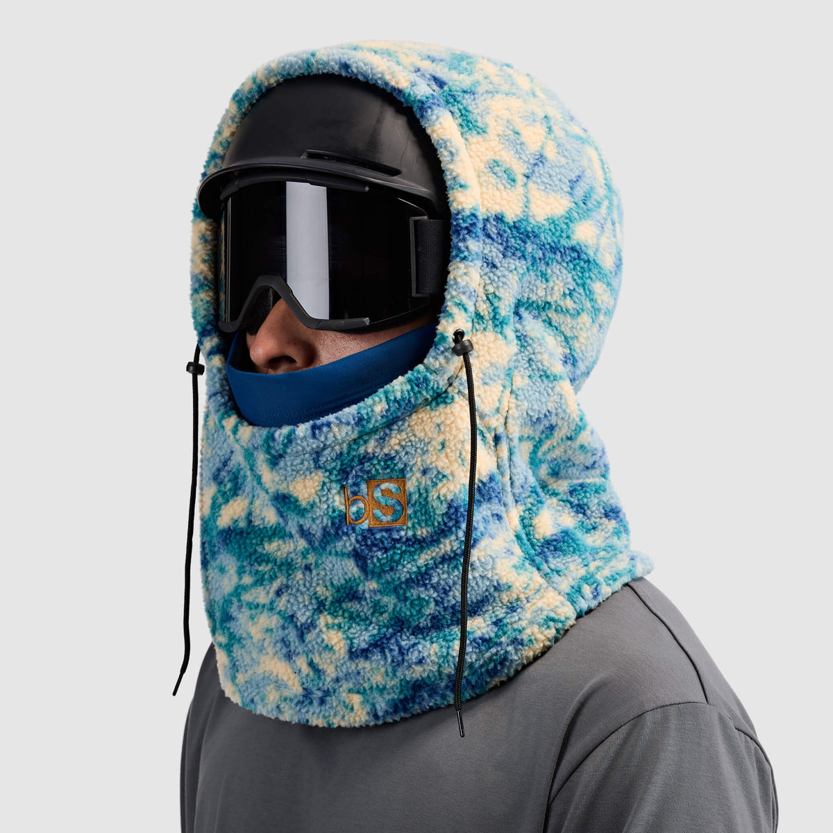 BlackStrap Caldera Hood Sherpa Fleece Overhood Pulse Deschutes worn by a man wearing a helmet and ski goggles #color_pulse-deschutes