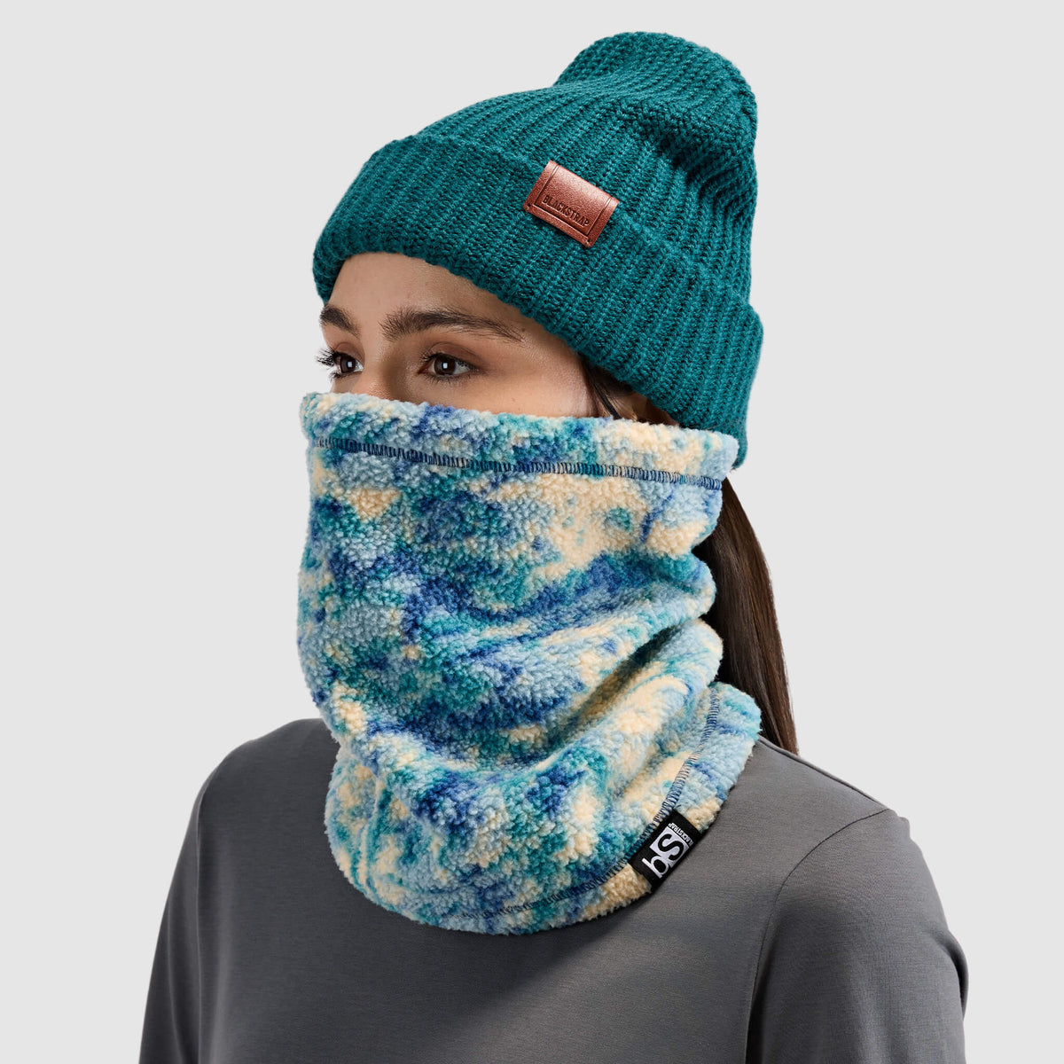 BlackStrap Caldera Sherpa Fleece Tube Neck Gaiter Pulse Deschutes worn by a woman with a beanie #color_pulse-deschutes