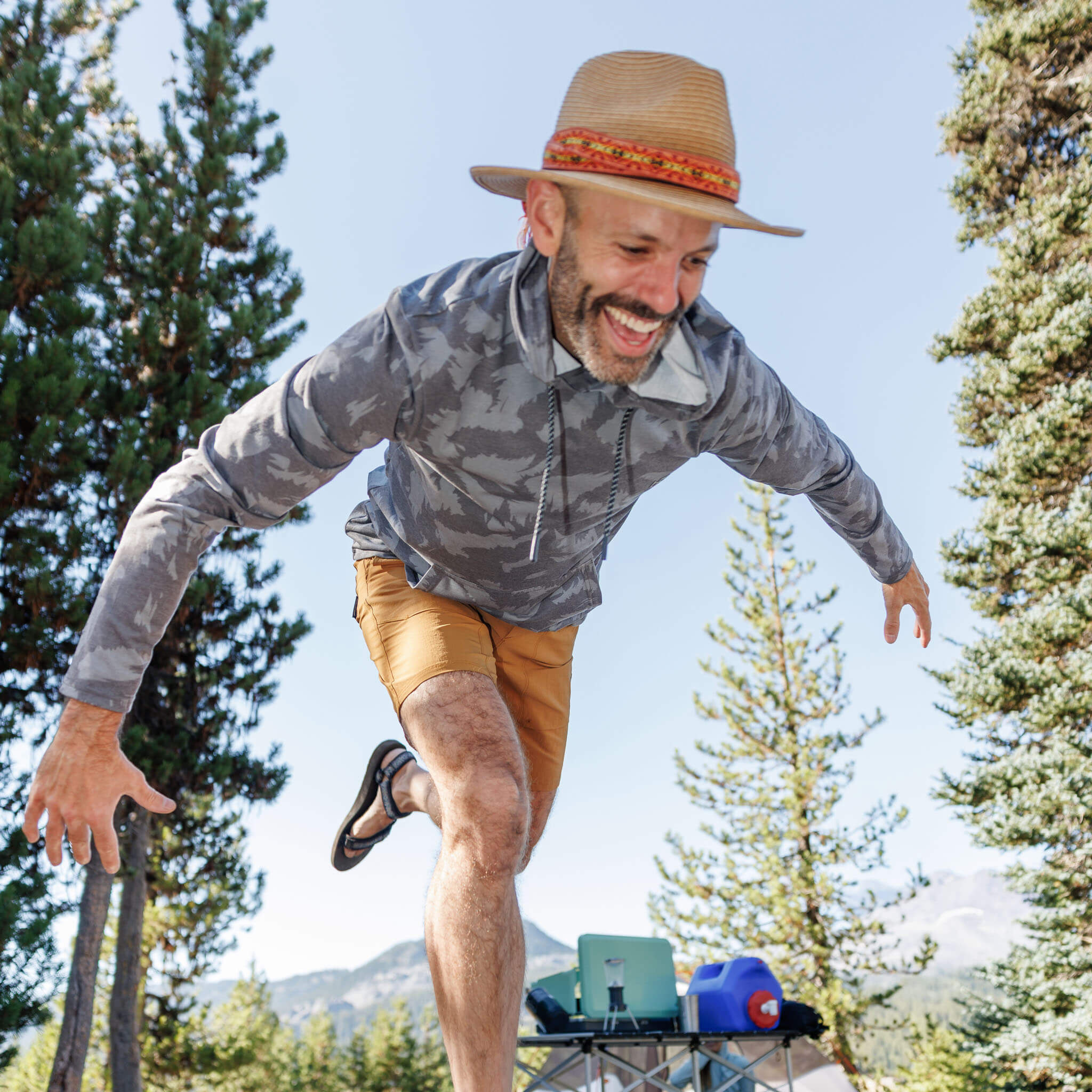 Man jumping at a mountain campsite wearing the BlackStrap Men's Aspect Hoodie Long Sleeve