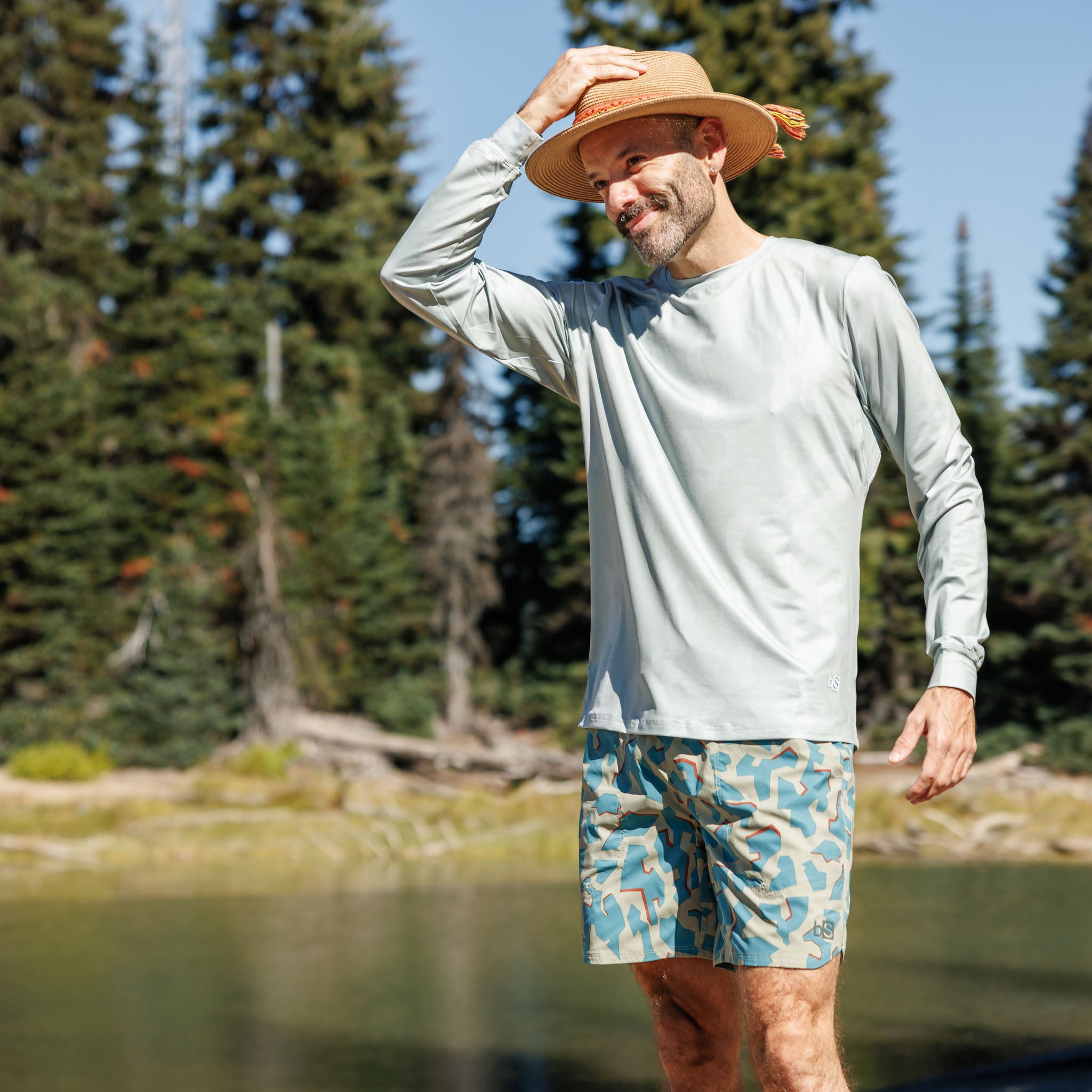 Man wearing the BlackStrap Evap Short in dimentical sagebrush at the lake with a Brackish long sleeve sun shirt