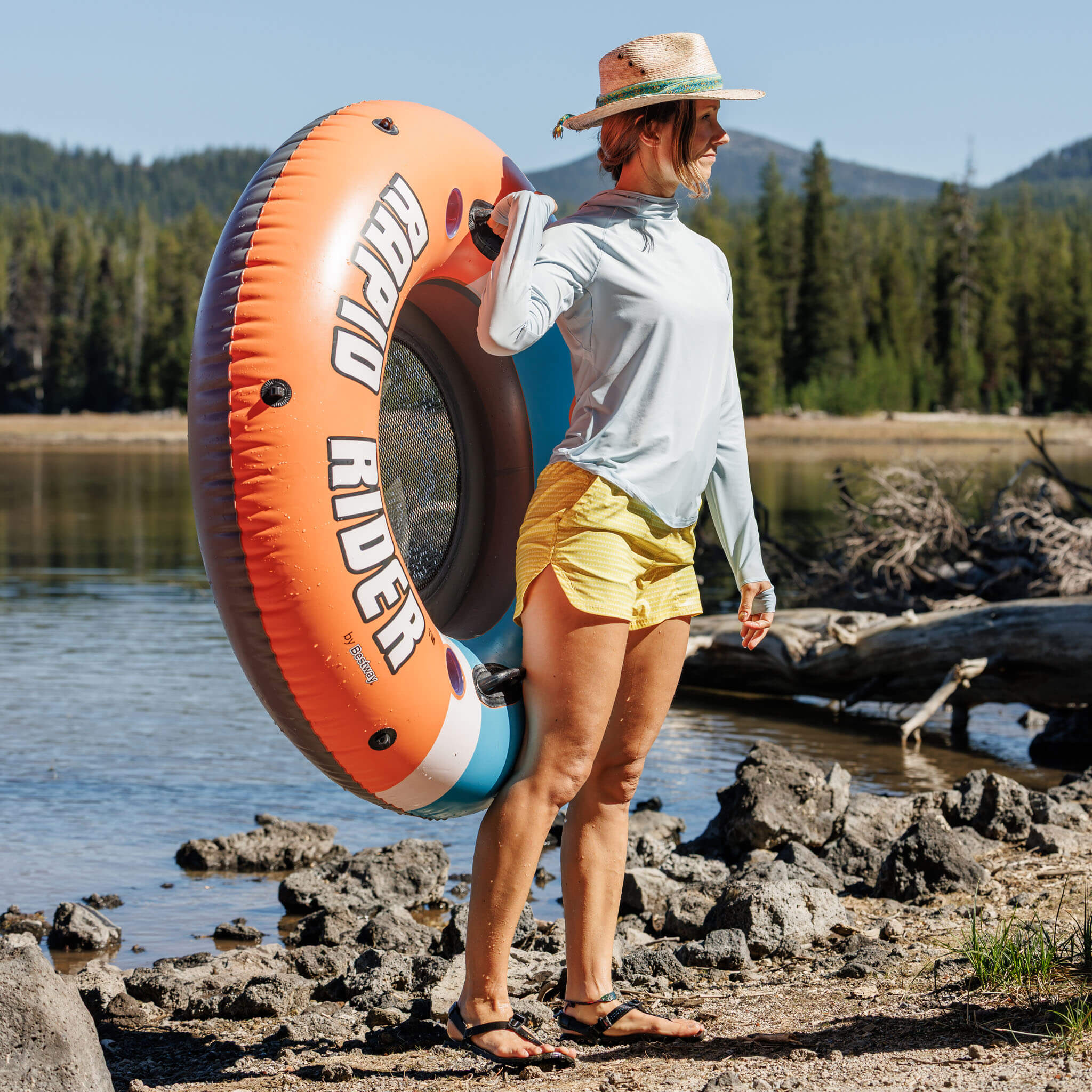 Women at the lake with an innertube floaty wearing the BlackStrap Evap Short and Brackish Sun Hoodie #color_sharktooth meadow